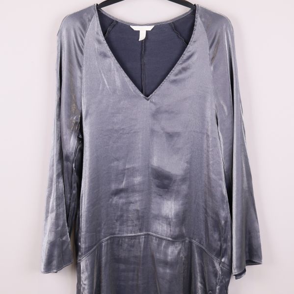 Närbild på överdelen av den silvriga klänningen med v-ringning