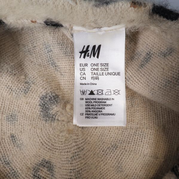 Närbild på material- och skötselråd etikett i baskern från H&M