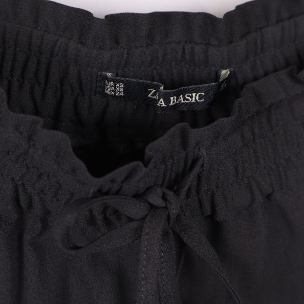 Närbild på midja och dragsko samt etikett ZARA BASIC