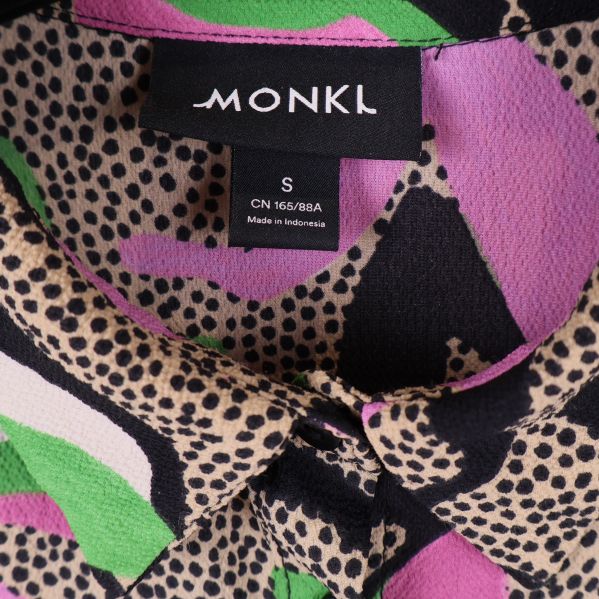 Närbild på Monki-logotyp och storlekslapp i nacken