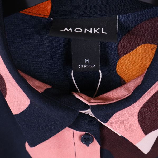 Närbild på Monki-etikett och krage på klänning