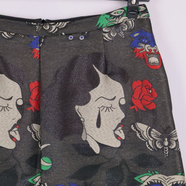 Närbild på kjolens mönster med kvinnoansikte och röda rosor