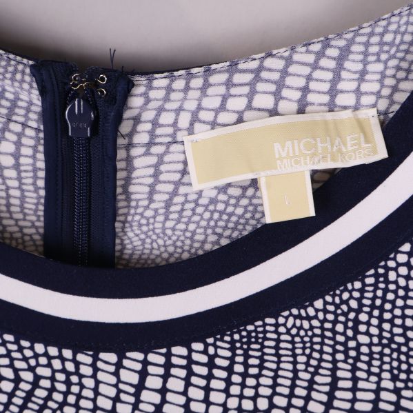 Närbild på halsringning och märkesetikett Michael Kors