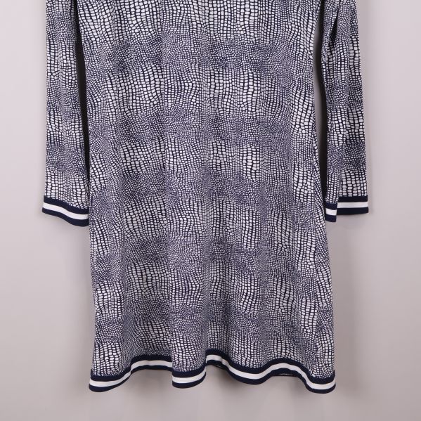 Närbild på klänningens nederkant och ribbstickade band