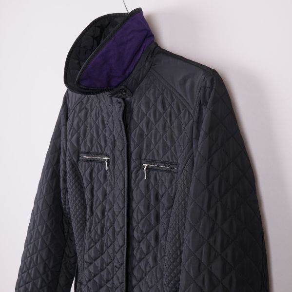 Närbild av jackans krage med lila insida och axelparti