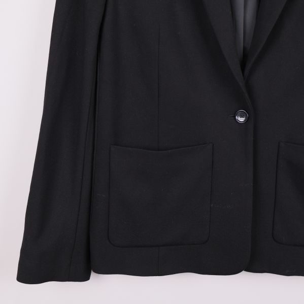 Nedre del fram på svart kavaj med öppen ficka