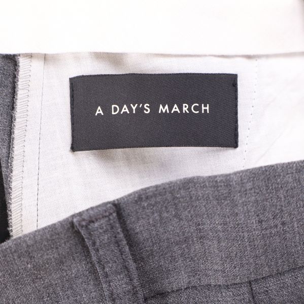 Närbild på varumärkesetikett A Day's March i byxlinning