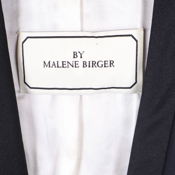 Närbild på vit etikett med texten By Malene Birger