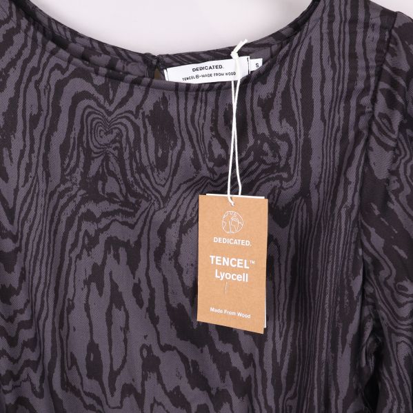 Närbild på TENCEL tag med varumärkesetikett vid halsen