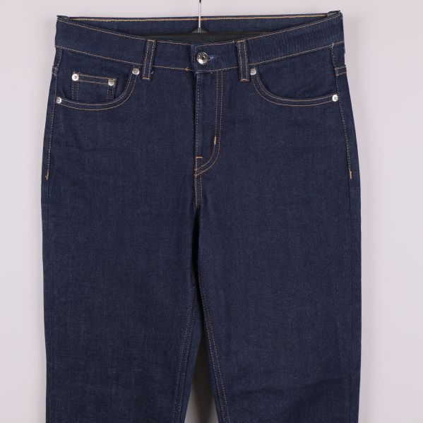 Närbild på midja och framfickor på mörkblå jeans