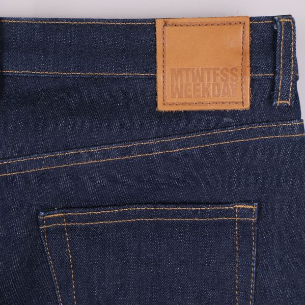 Närbild på bakficka och läderpatch med Weekday-logga