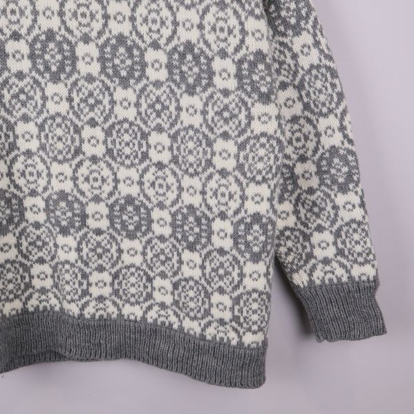 Ärmdetalj på stickad tröja med jacquardmönster