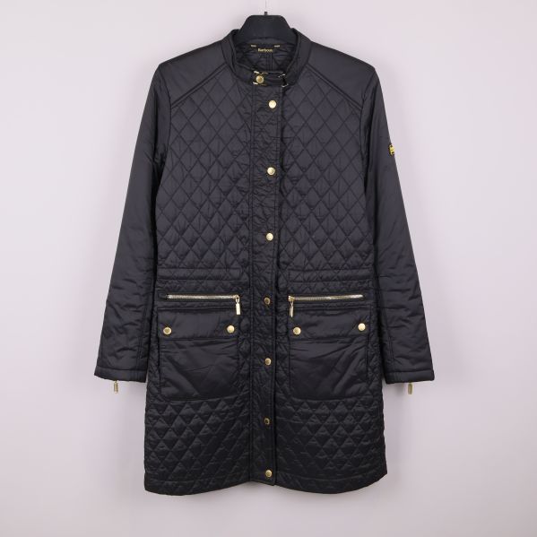 Framsida av svart quiltad Barbourjacka med guldknappar