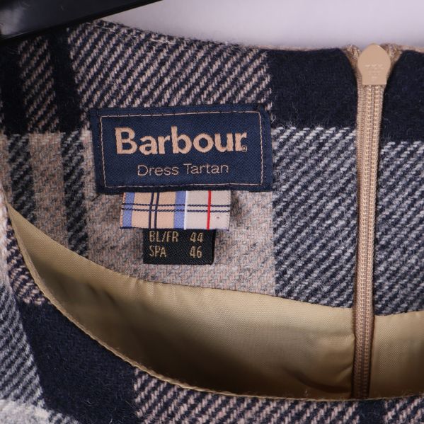 Närbild inuti klänning med Barbour-märkesetikett och storlekslapp