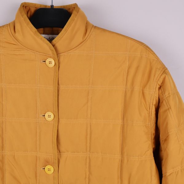 Närbild på knäppning och axelparti hos jackan