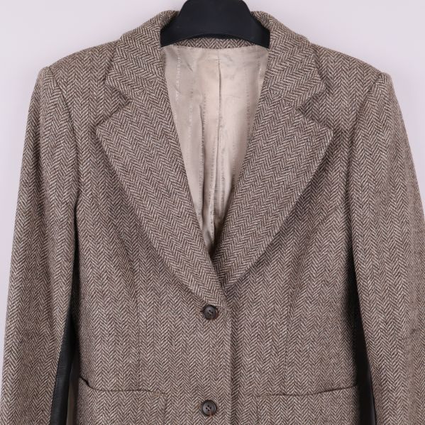 Närbild på krage och axel på fiskbensmönstrad blazer