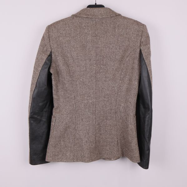 Baksida av blazer med svarta skinnpaneler på armarna