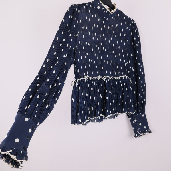 Sned vy av blus med plisserat tyg och prickigt mönster