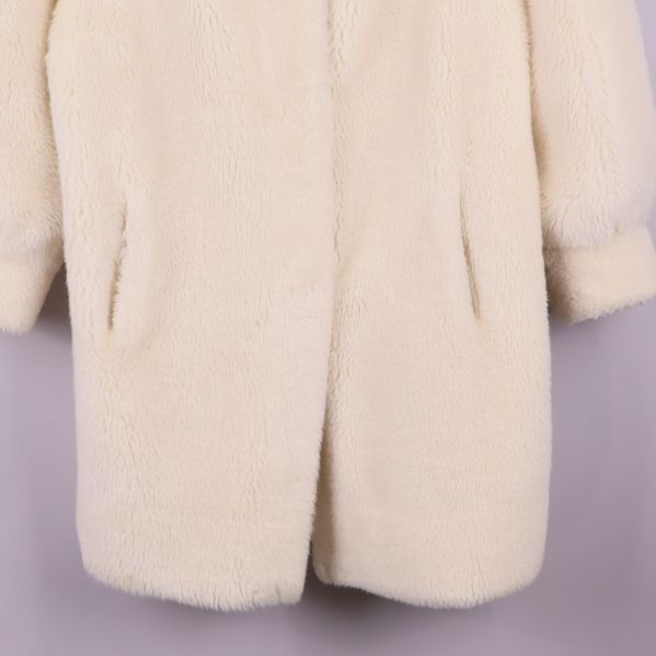 Närbild av kappa med fickor och nederkant synlig