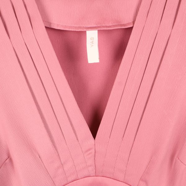 Närbild på plisserad V-ringning och etikett Y.A.S