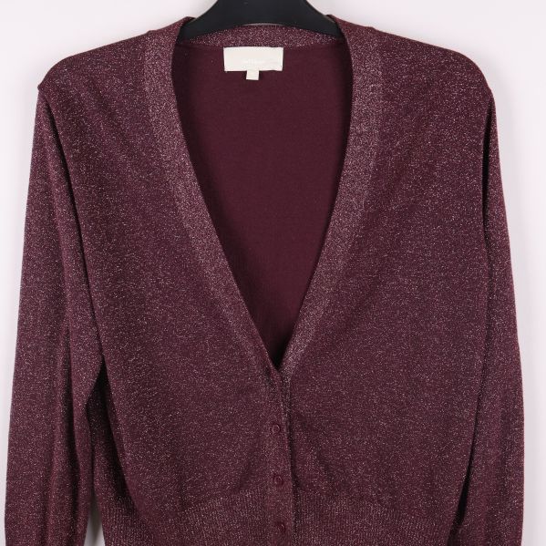 Närbild på koftans glittriga material och knäppning