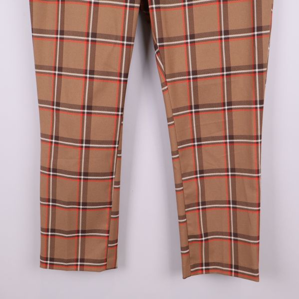 Rutiga byxben med kort ankellängd visas i närbild