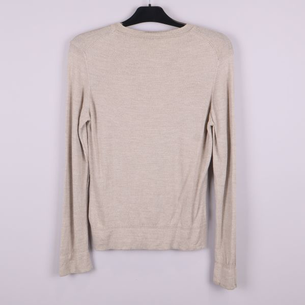 Baksidan av beige långärmad kofta