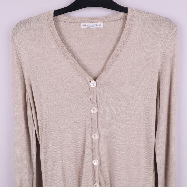Övre del av beige kofta med v-ringning och knappar