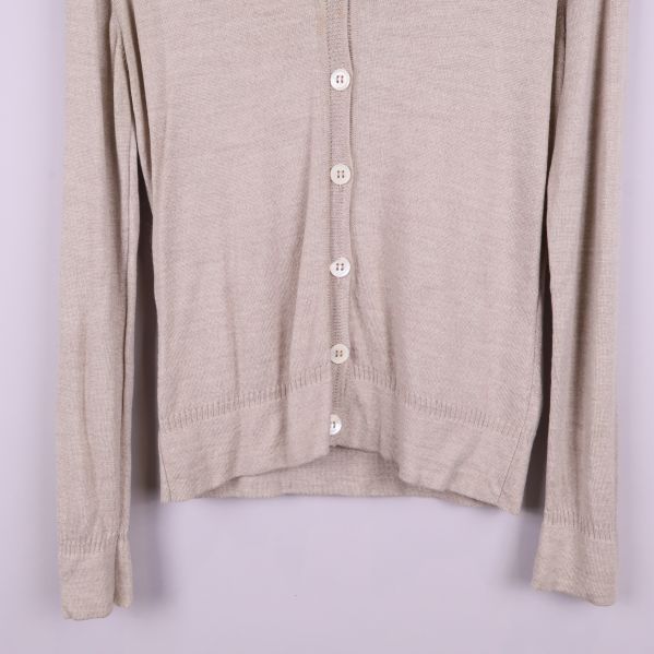 Nederkant av beige kofta med ribbad fåll