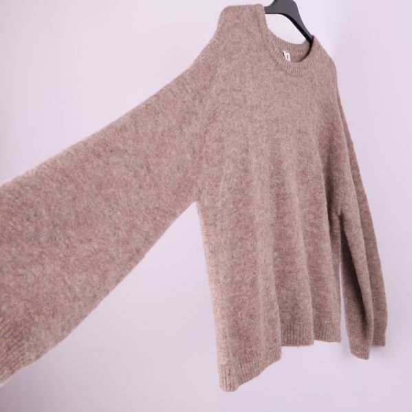 Beige stickad tröja med utsträckt ärm från sidan