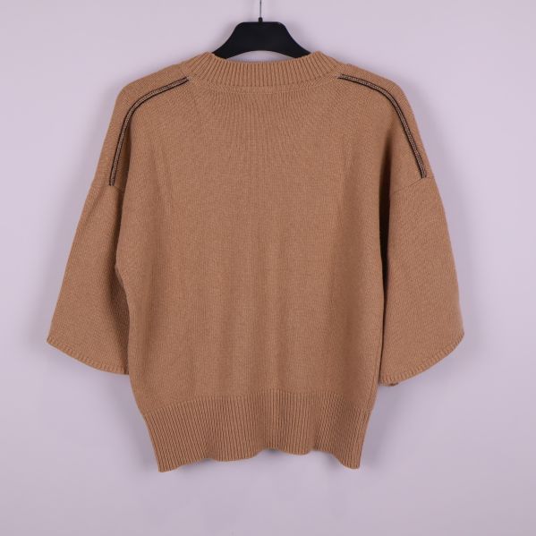 Baksida av beige stickad tröja med ribbad kant