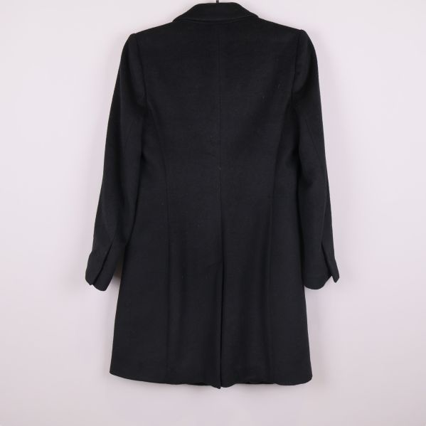 Svart kappa fotograferad bakifrån mot ljus bakgrund