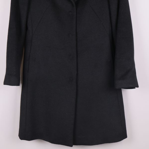 Kappans nedre del visas i närbild mot ljus bakgrund