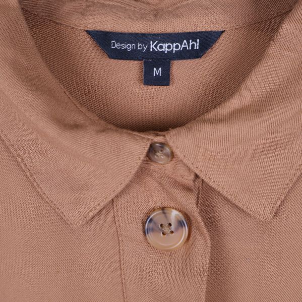 Närbild på krage och knapp samt KappAhl-märkning
