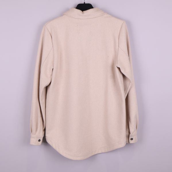 Baksidan av beige overshirt visas upp hängande