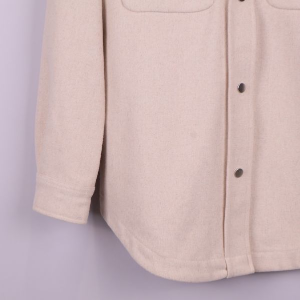 Nedre delen av overshirt och ärmslut i beige tyg