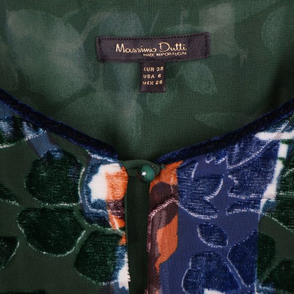 Närbild på Massimo Dutti-etikett och knappdetalj i halsringningen