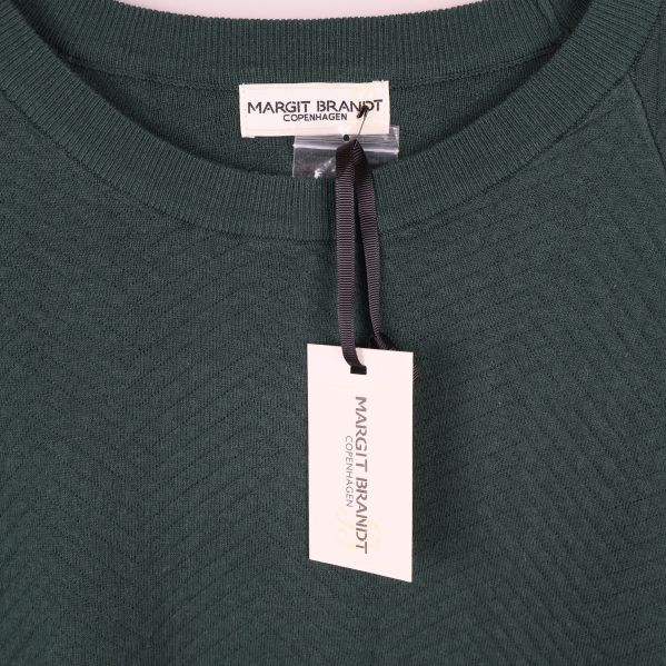 Närbild på Margit Brandt-märke och halsringning