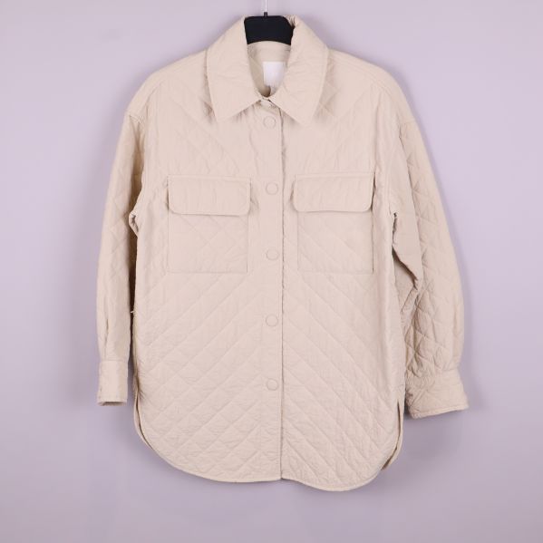 Framsida av quiltad beige overshirt med två fickor