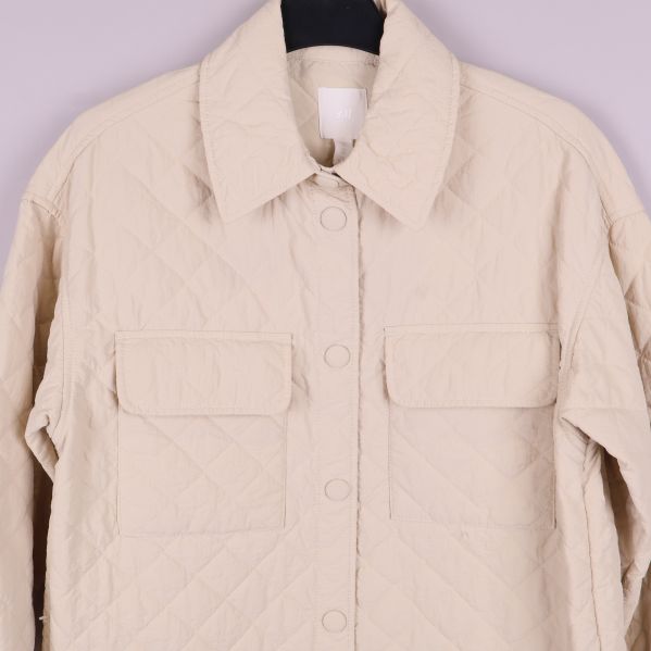 Närbild på bröstfickor och knappar av quiltad overshirt