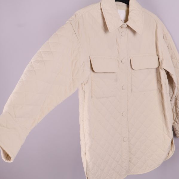 Quiltad beige overshirt fotograferad från sidan