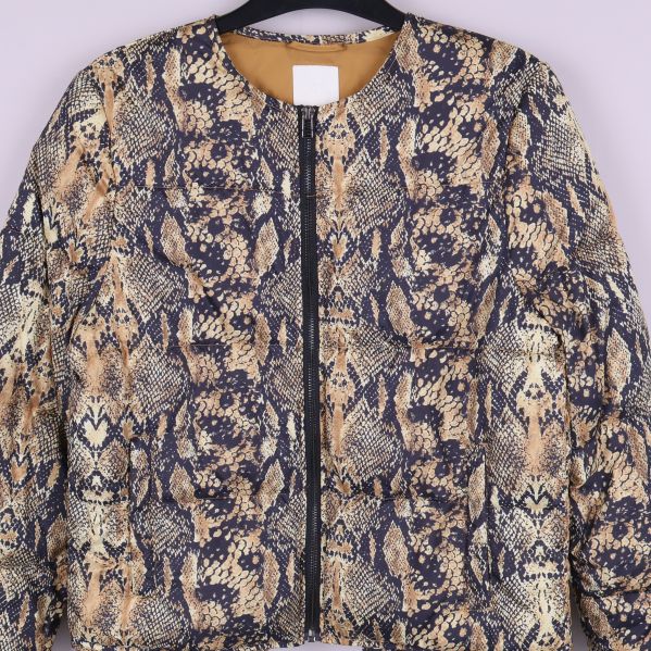 Närbild på framdelen av jacka med ormmönster och dragkedja