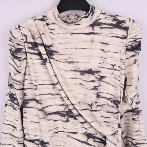 Närbild på axel och hals på batikklänning