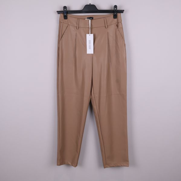 Beiga byxor i skinnimitation upphängda framifrån