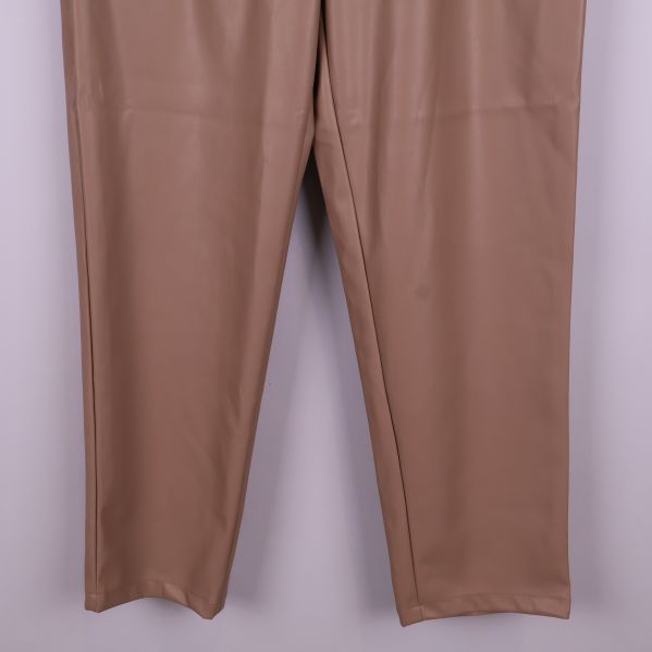 Närbild på nederdelen av beiga byxben