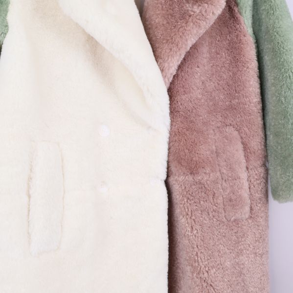 Närbild på ficka och söm på färgblockad teddy kappa