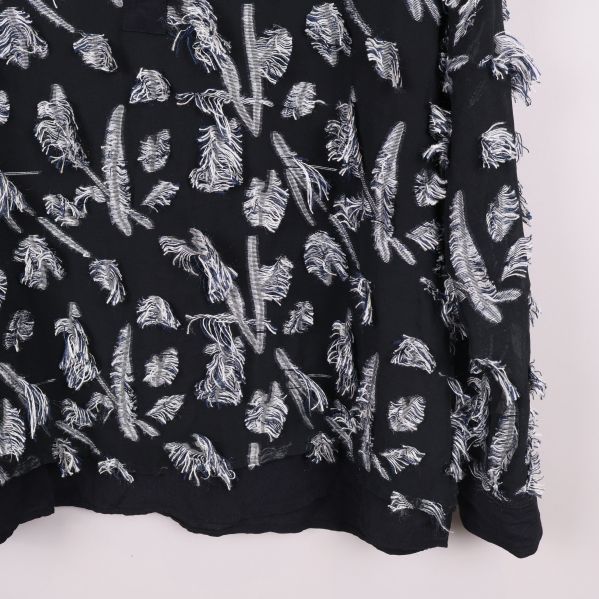 Närbild på nedre del av blus med broderier