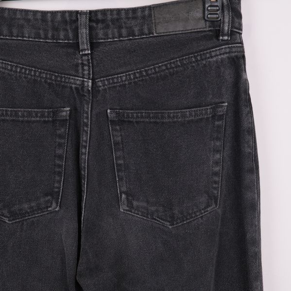 Närbild på bakfickor och midja av svarta jeans