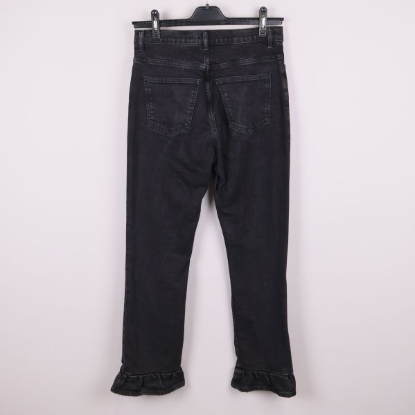 Svarta jeans med volangkant upphängda bakifrån