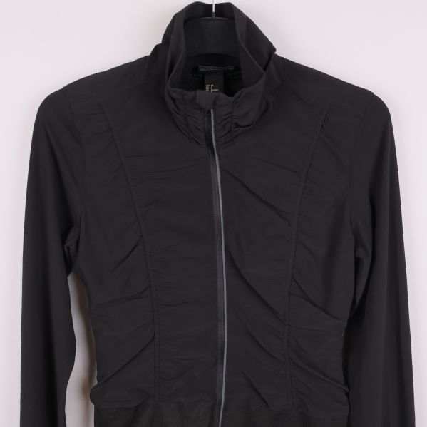 Framsida av svart sportjacka, övre del och dragkedja